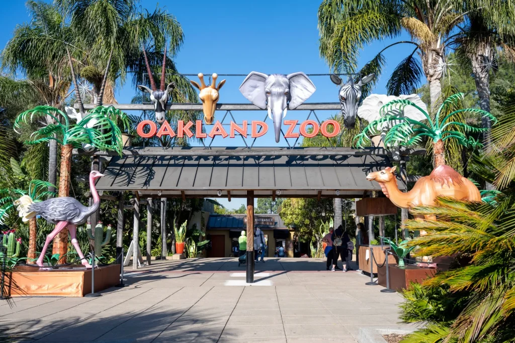Oakland, California - November 12, 2021: Entrance to the Oakland Zoo on a sunny day, with animal representations and plants decorating the walkway.