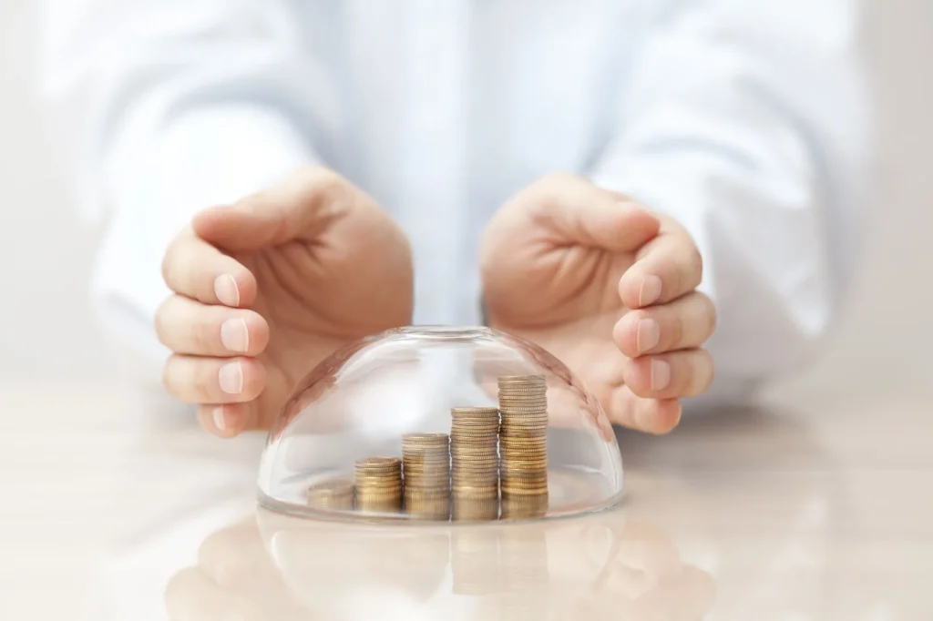 Rising coins protected under a glass dome and hands