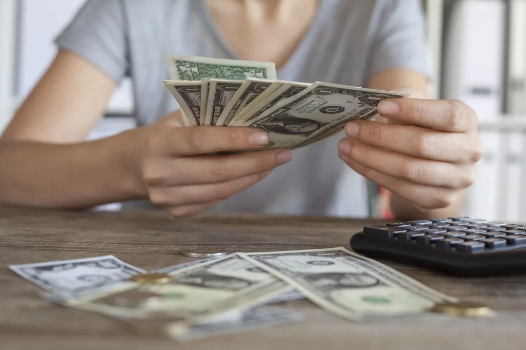 close up of woman counting money and getting finances in order