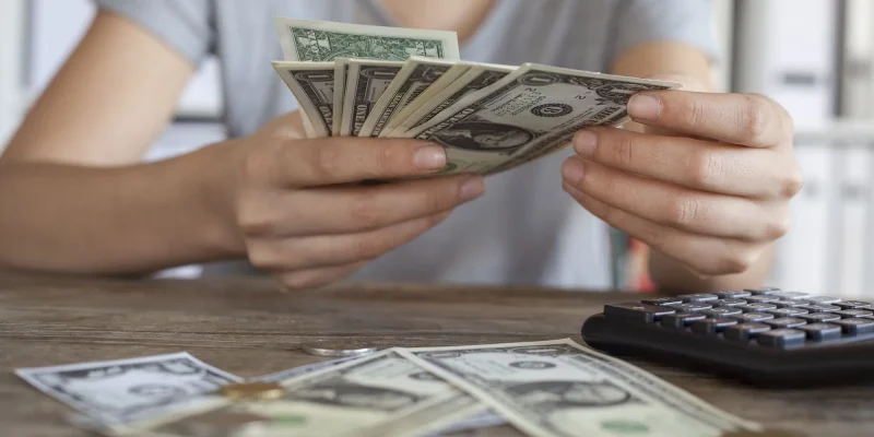 close up of woman counting money and getting finances in order