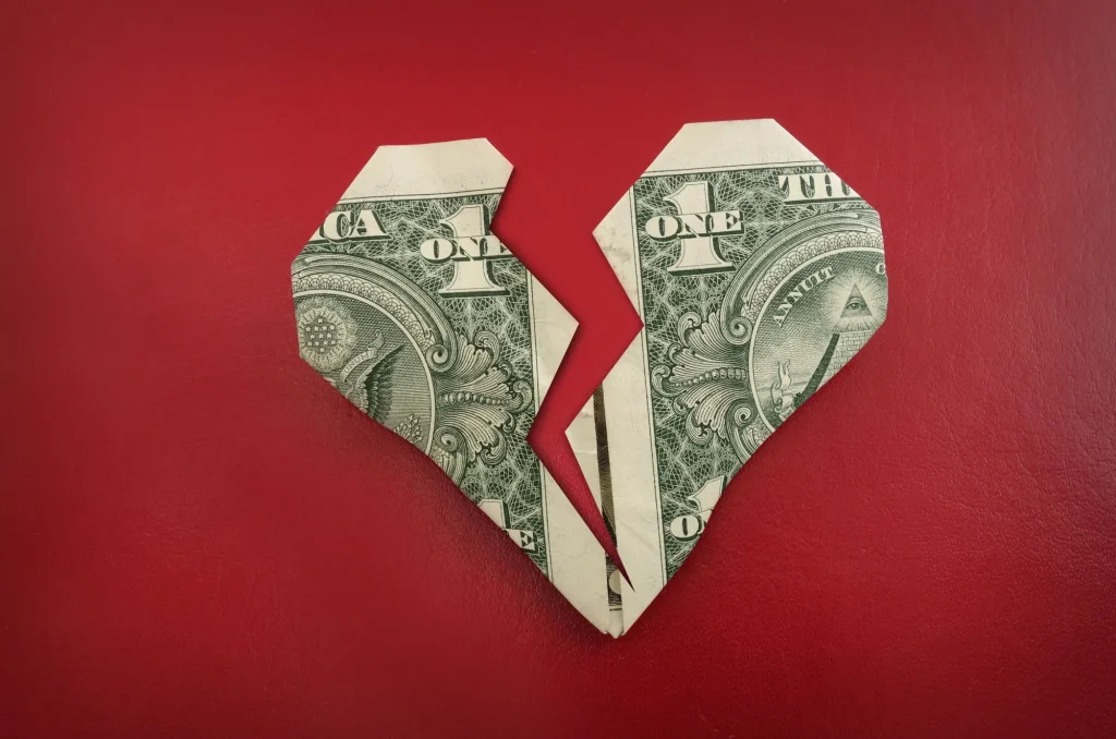A broken origami dollar heart, on red