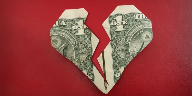 A broken origami dollar heart, on red