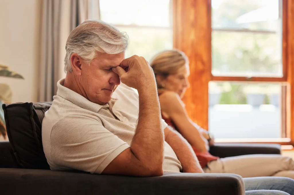 annoyed depressed unhappy retired couple on couch not speaking