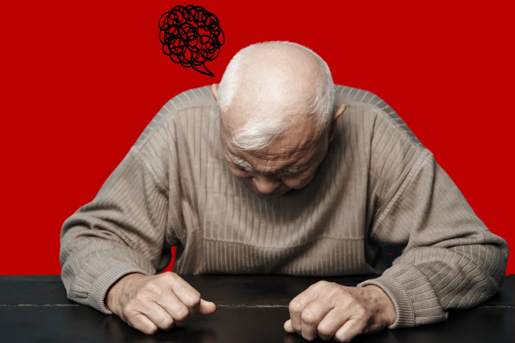 old man depressed slumped over table