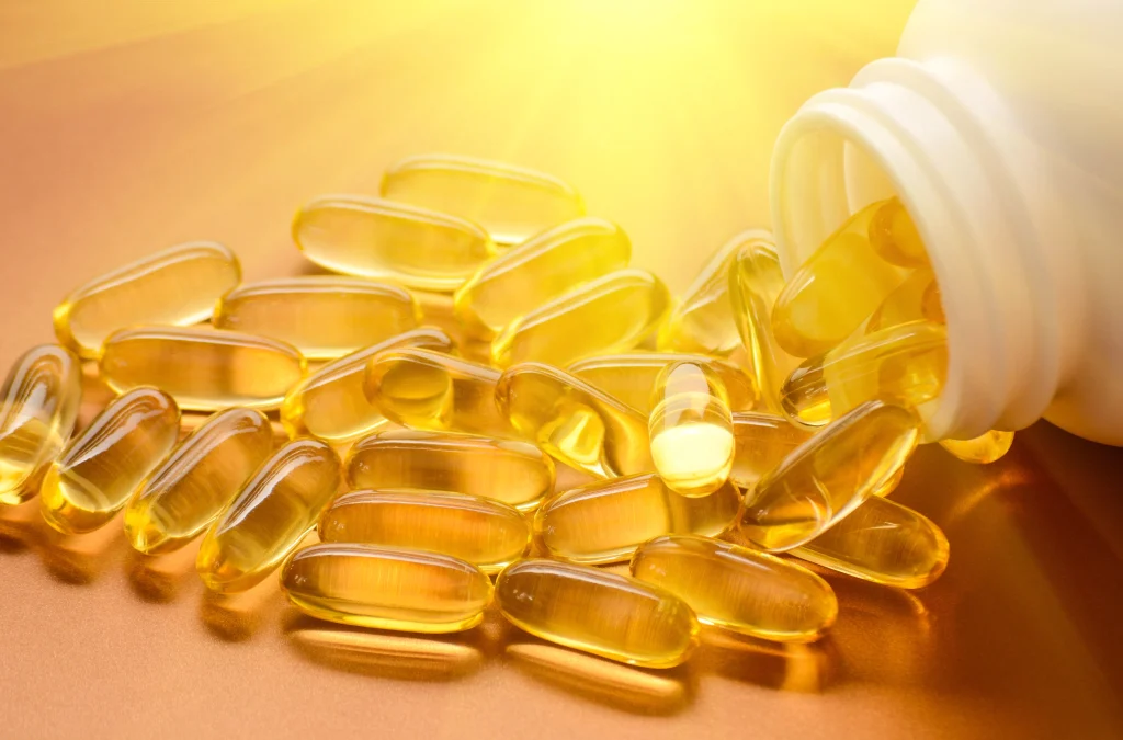 fish oil pills being spilled out of a bottle close up
