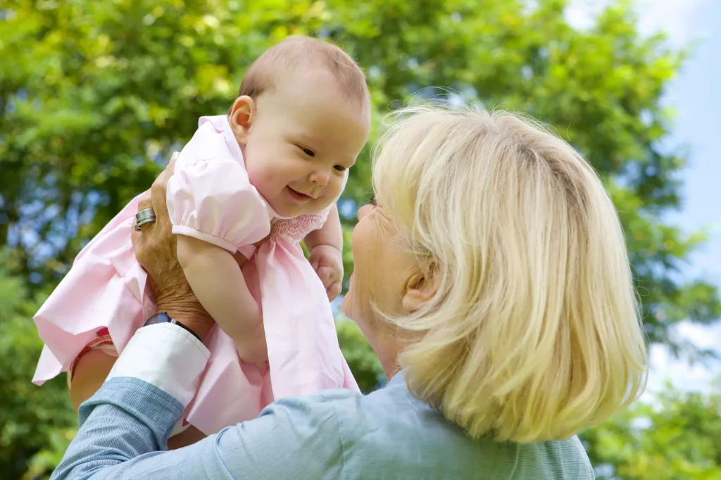 grandmother holding baby up