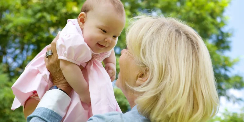 grandmother holding baby up