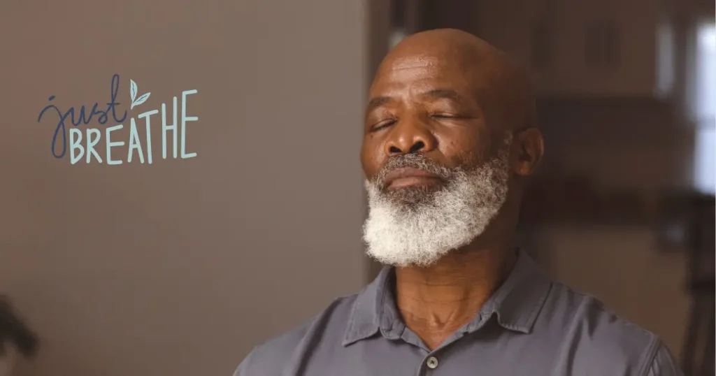 black senior man taking a deep breath with the words just breathe floating next to him