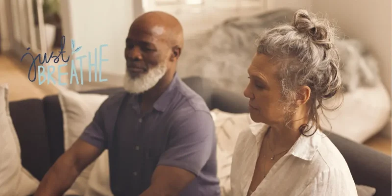 two seniors sitting down doing breathwork