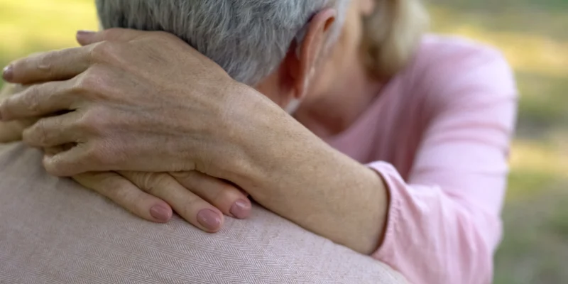 Female hands hugging husband neck