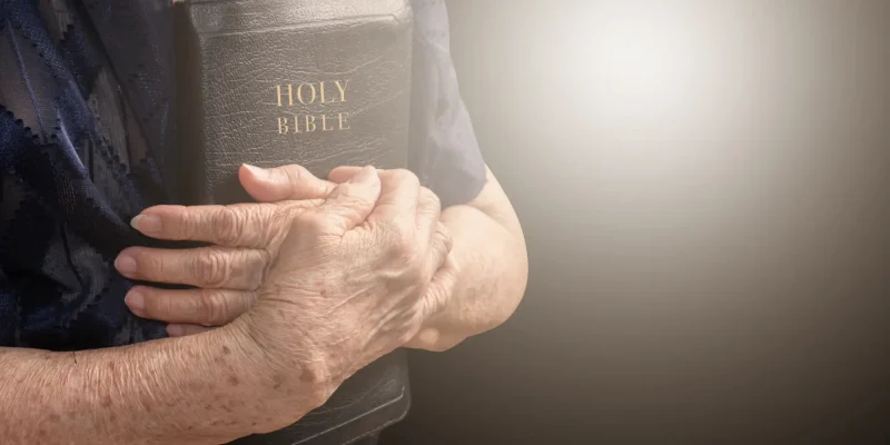 older adult holding a bible