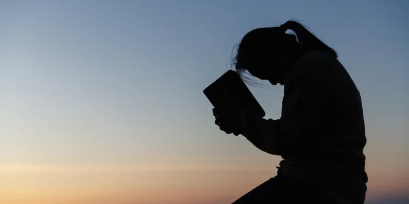praying outside with a bible, silhouette
