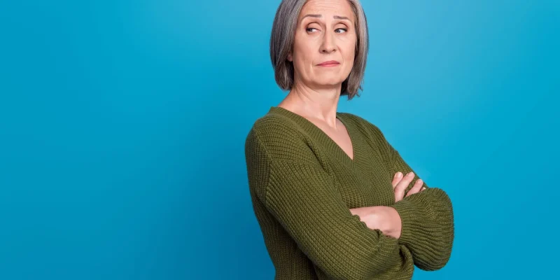 Photo of egoist selfish businesswoman pensioner wear khaki jumper folded hands look empty space arrogant isolated over blue background