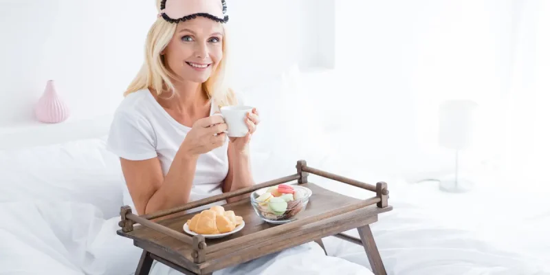 Portrait of her she nice attractive lovely aged cheerful woman mother mom having breakfast lunch meal snack everyday good habit life in modern light white interior room flat apartment