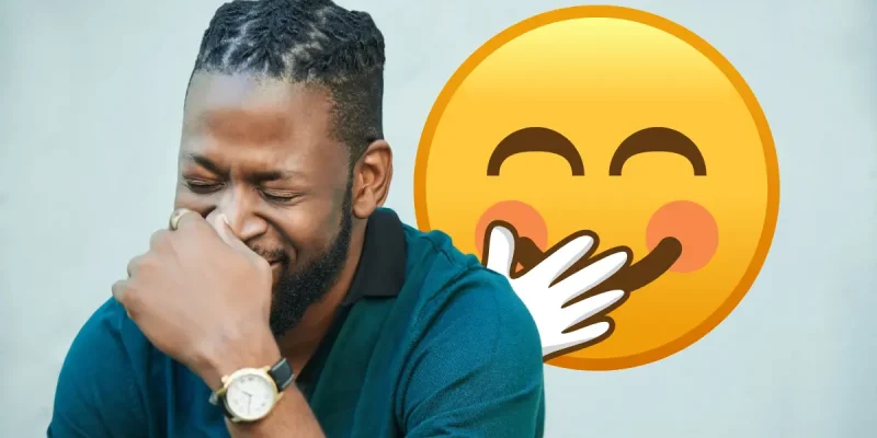 black man sitting down trying not to laugh with a yellow laughing emoji in the background