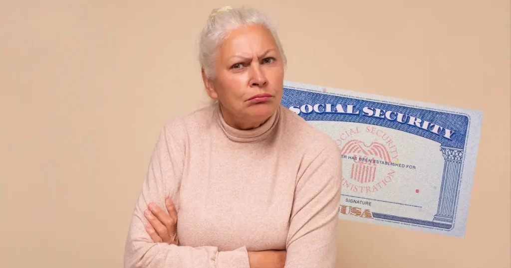 senior retired woman with arms crossed and face scrunched in front of a social security card