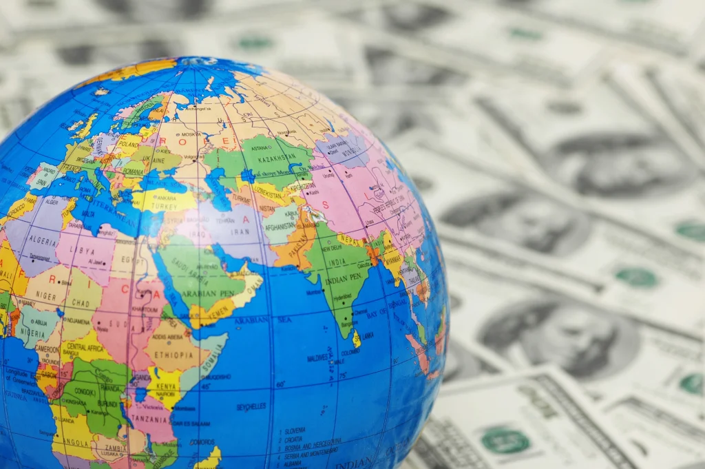 world globe in foreground and out of focus money in the background