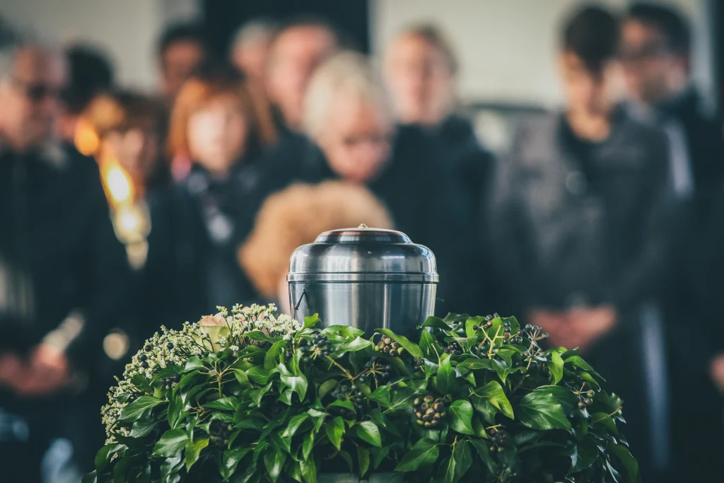 metal urn cremation with funeral in the background blurred