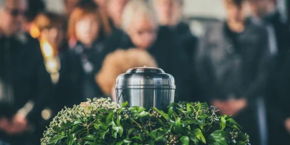 metal urn cremation with funeral in the background blurred