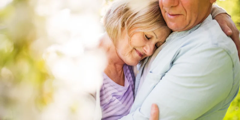 older couple hugging outside