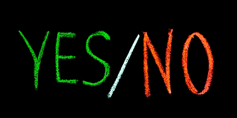 yes or no written in green and red chalk on a black background
