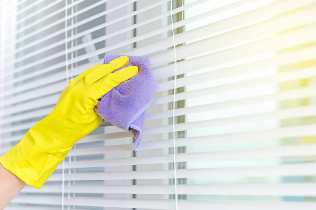 yellow glove wiping blinds