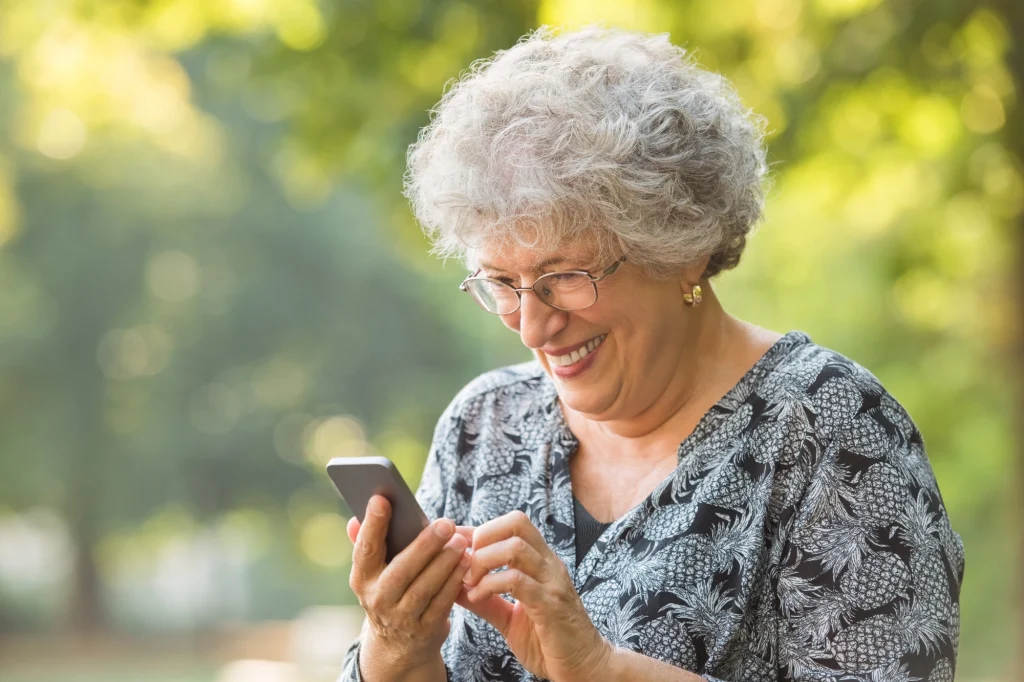 senior woman looking at a phone and smiling