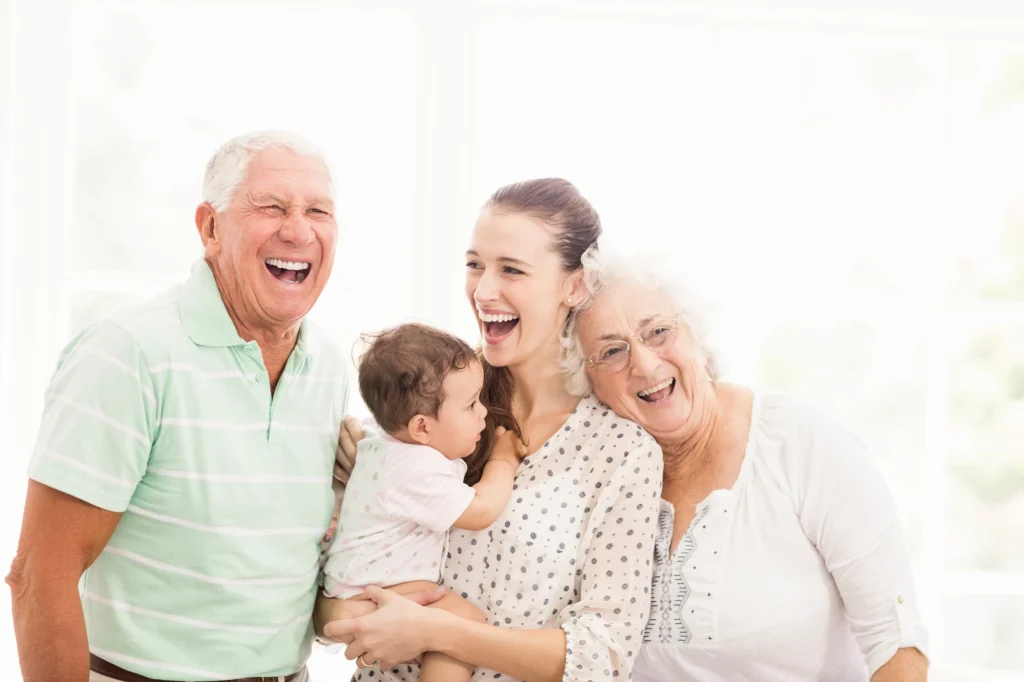 grandparents laughing with new mom and grandbaby