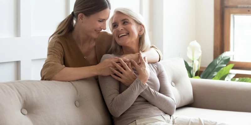 mom and daughter hug on couch