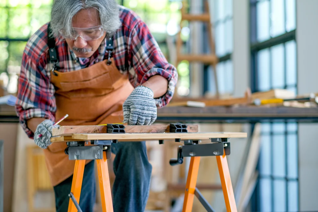 Old or senior Asian craftsman or carpenter act as measurement of wood in the room with wood pile and surround with glasses. Concept of activity for senior generation support good health