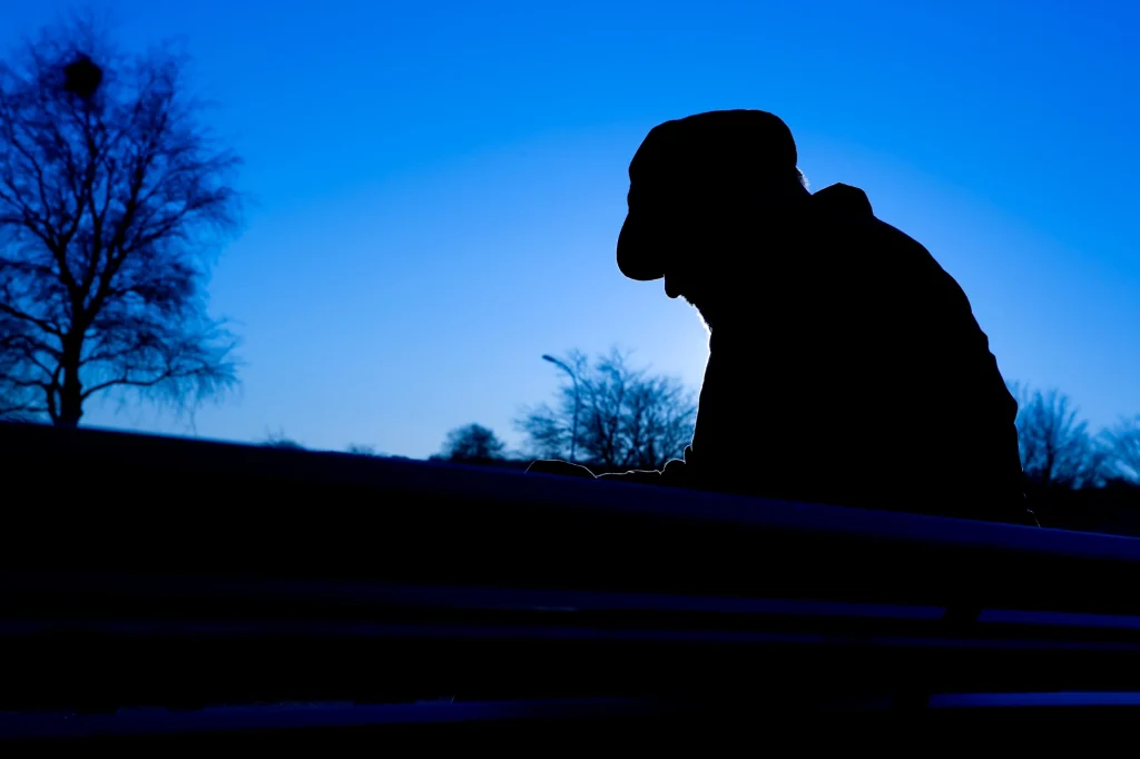 man sitting on bench depressed