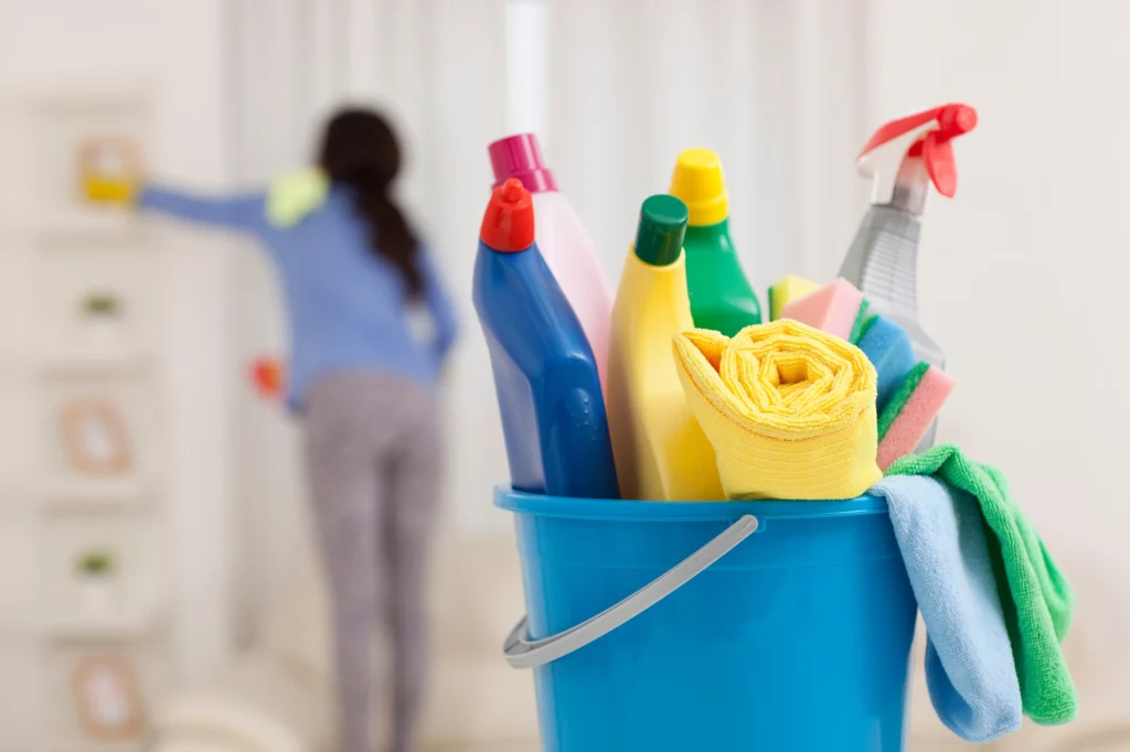 bucket of cleaning supplies in foreground being neglected for alternative cleaning methods