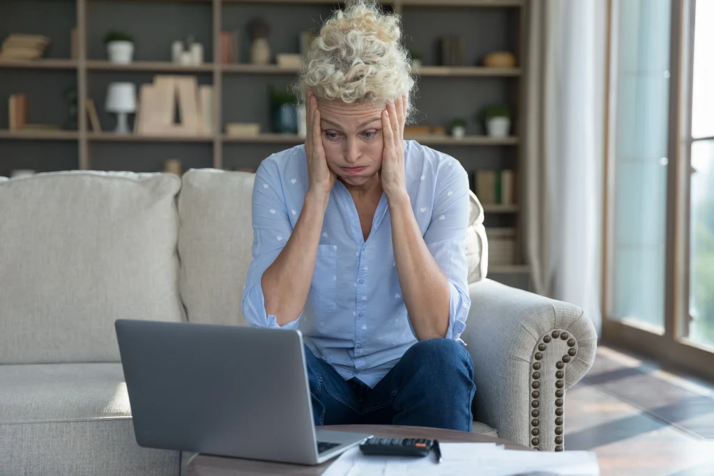confused, frustrated older woman sitting in front of her computer
