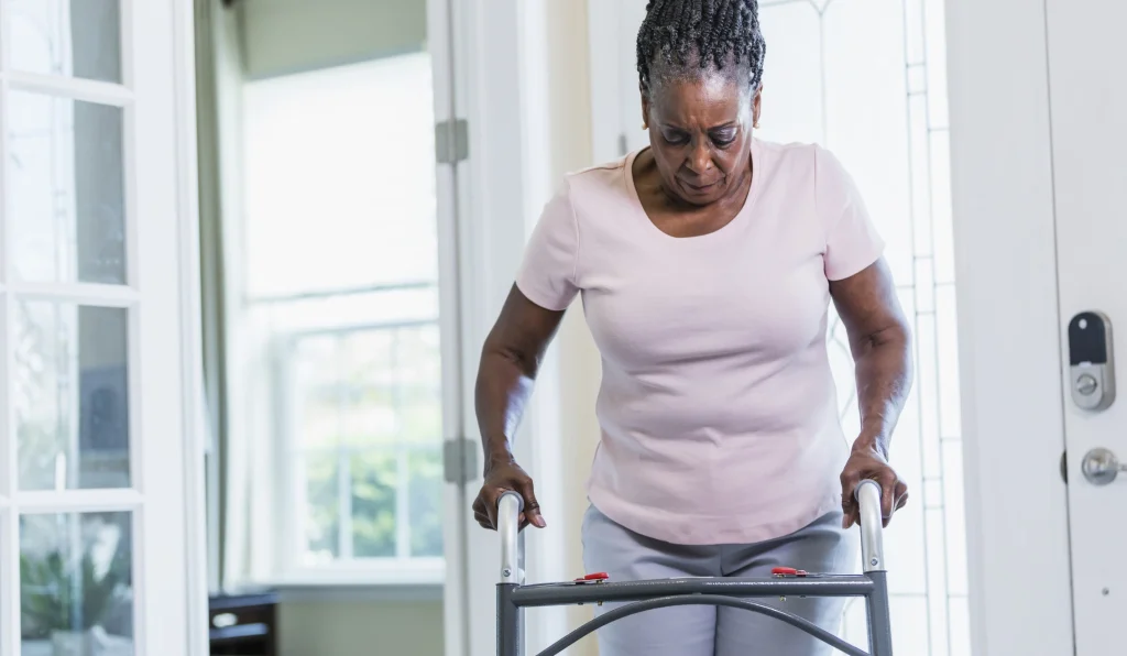 black senior woman using a walker to prevent falling and help mobility