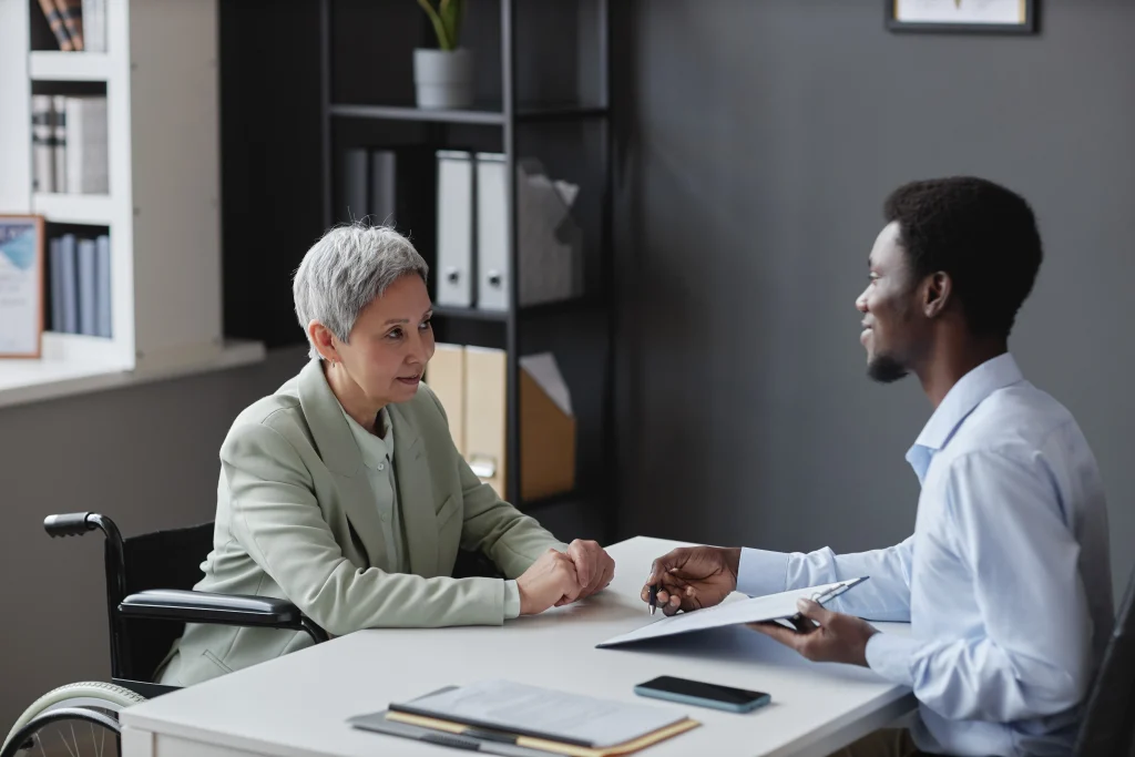 Side view portrait of mature woman with disability speaking to recruiter in job interview