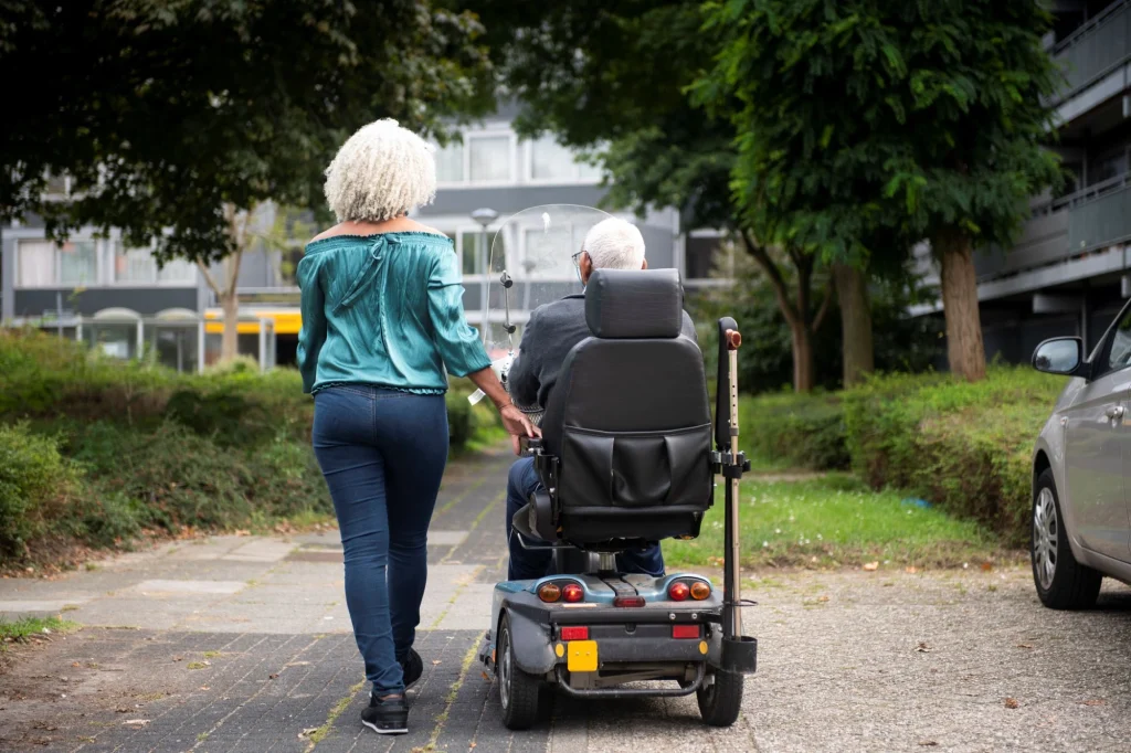 daughter walking outside with her dad mobility scooter