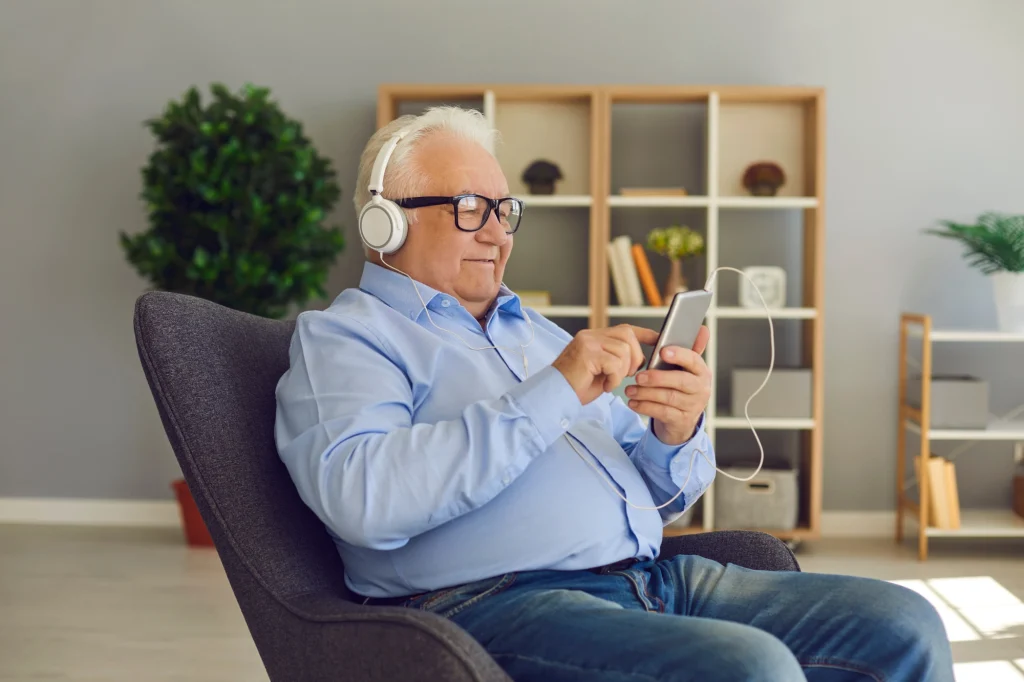 older man listening to headphones podcast
