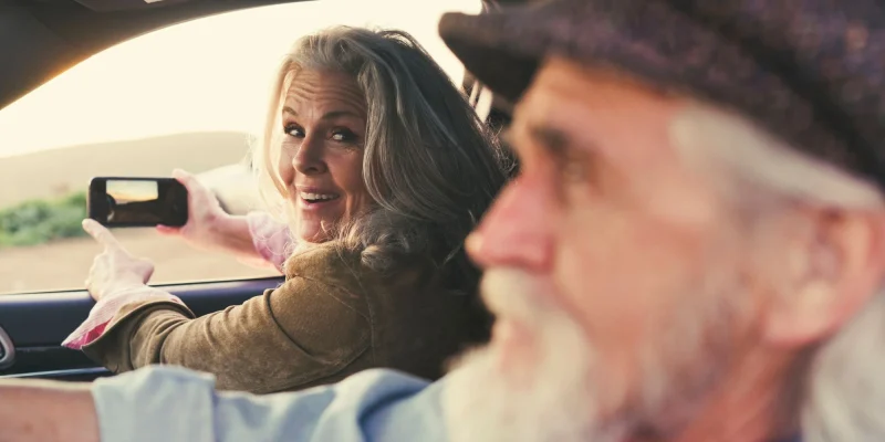 older senior couple in a car on a road trip