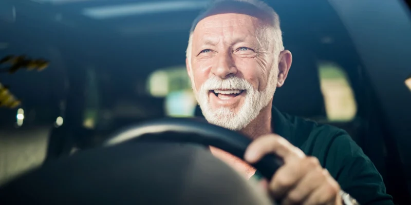 older man driving a car