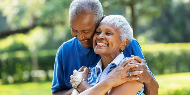 senior couple black hugging outside