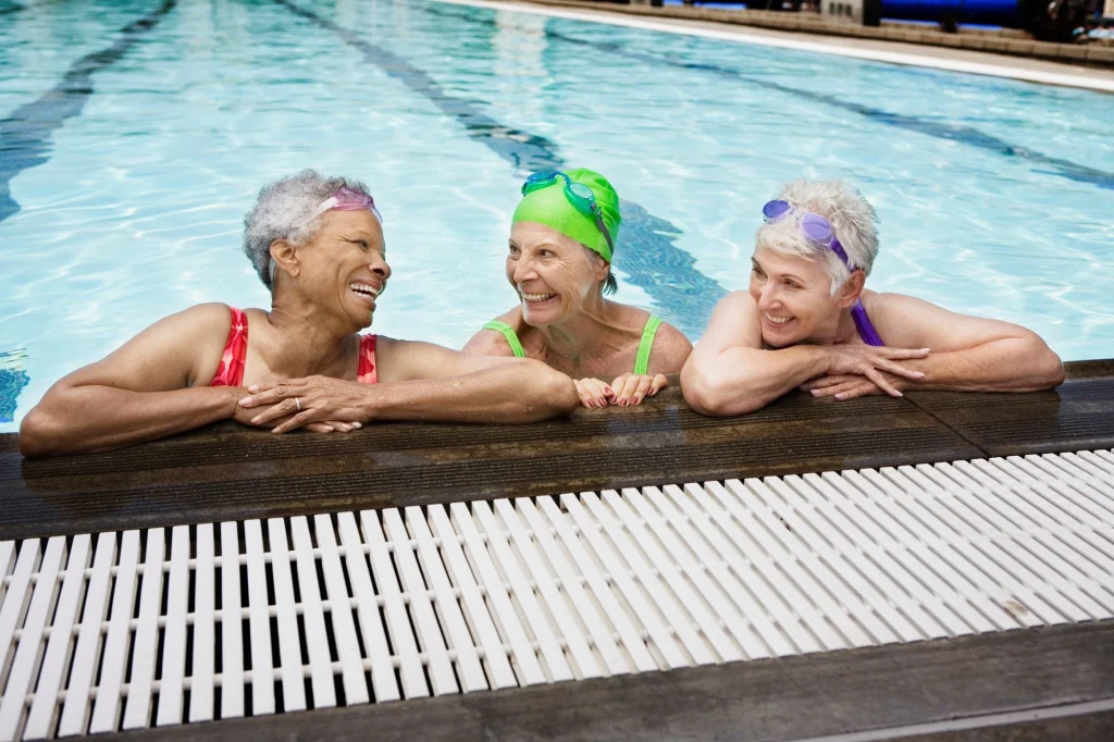senior ladies swimming in a pool having fun and smiling