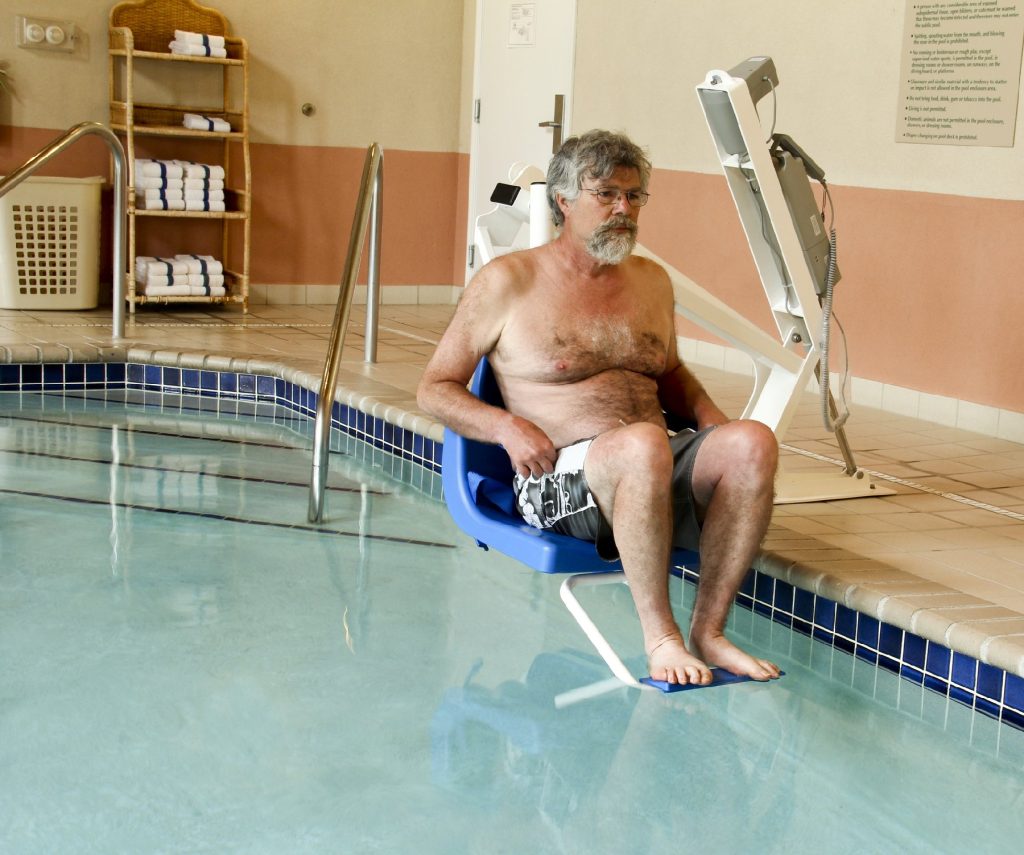 A swimming pool lift enables a disabled traveler to enjoy his hotel's pool. Photo courtesy of Dave Willman/Dreamstime.com.