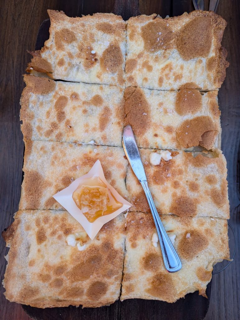 At Davanti Enoteca restaurant in San Diego's Little Italy, addicting Focaccia Di Recco -- Ligurian flatbread with soft cow's milk cheese and honeycomb -- is a favorite made for sharing. Photo courtesy of Athena Lucero.