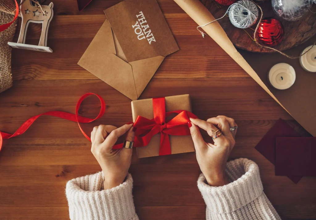 hands wrapping christmas present thank you