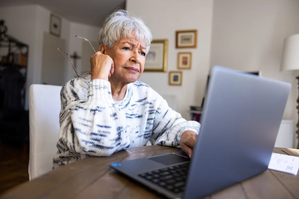 black senior woman looking worried at computer