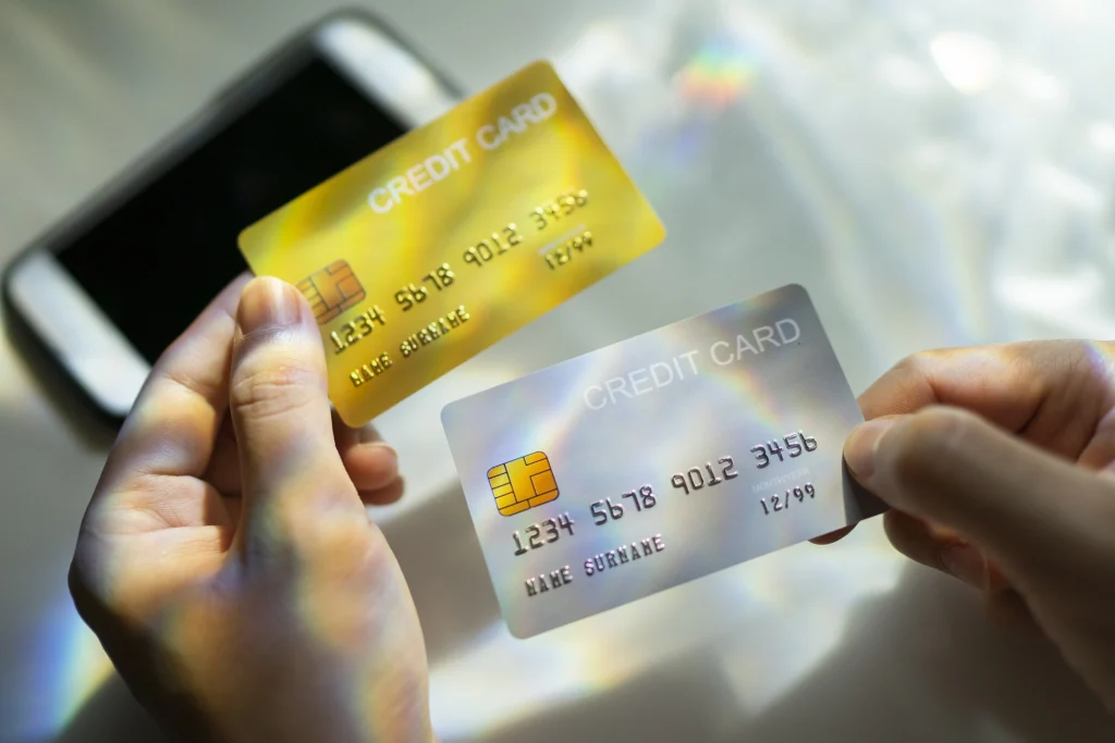 Hands holding multiple credit cards indicating debt