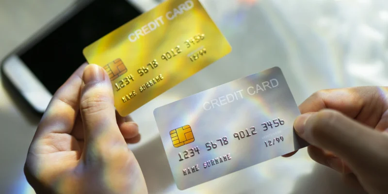 Close up Hand holding Blank credit card black,gold,platinum color with spectrum light and shadow background - stock photo