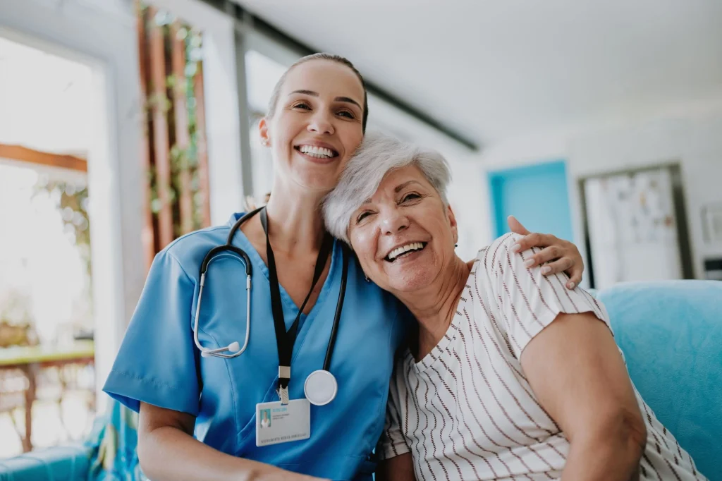 nurse and caregiver on couch smiling home care