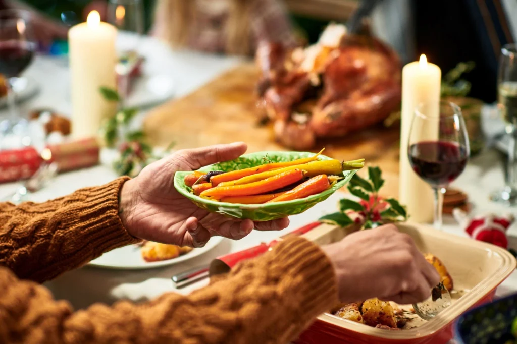 hand scooping up carrots christmas meal