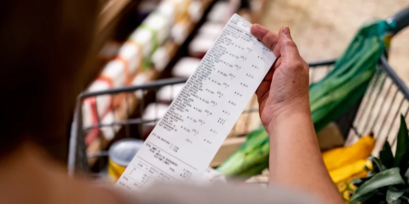 Close-up on a woman looking at a receipt after shopping at the supermarket